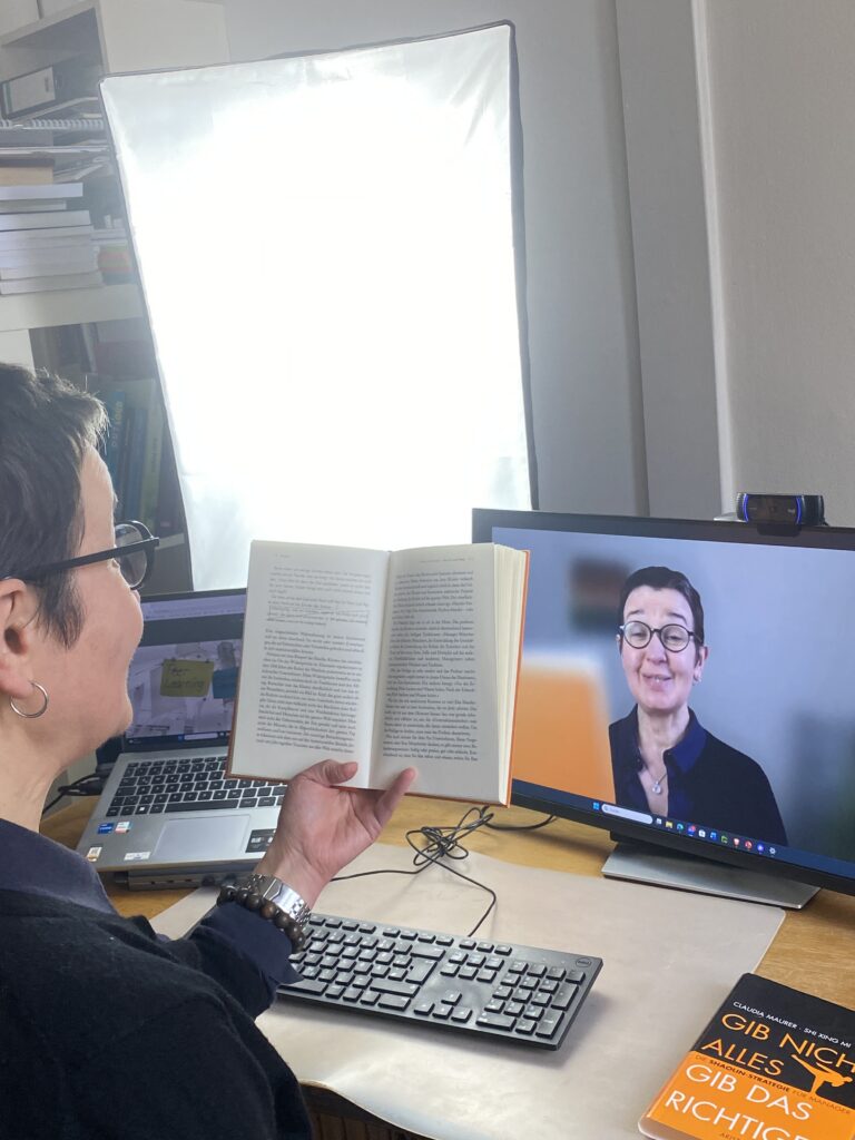 Bettina liest eine Geschichte vor. Ihr Gesicht ist sehr fokussiert auf's Vorlesen. Gleiches Setting wie das Headerbild, Hochformat.